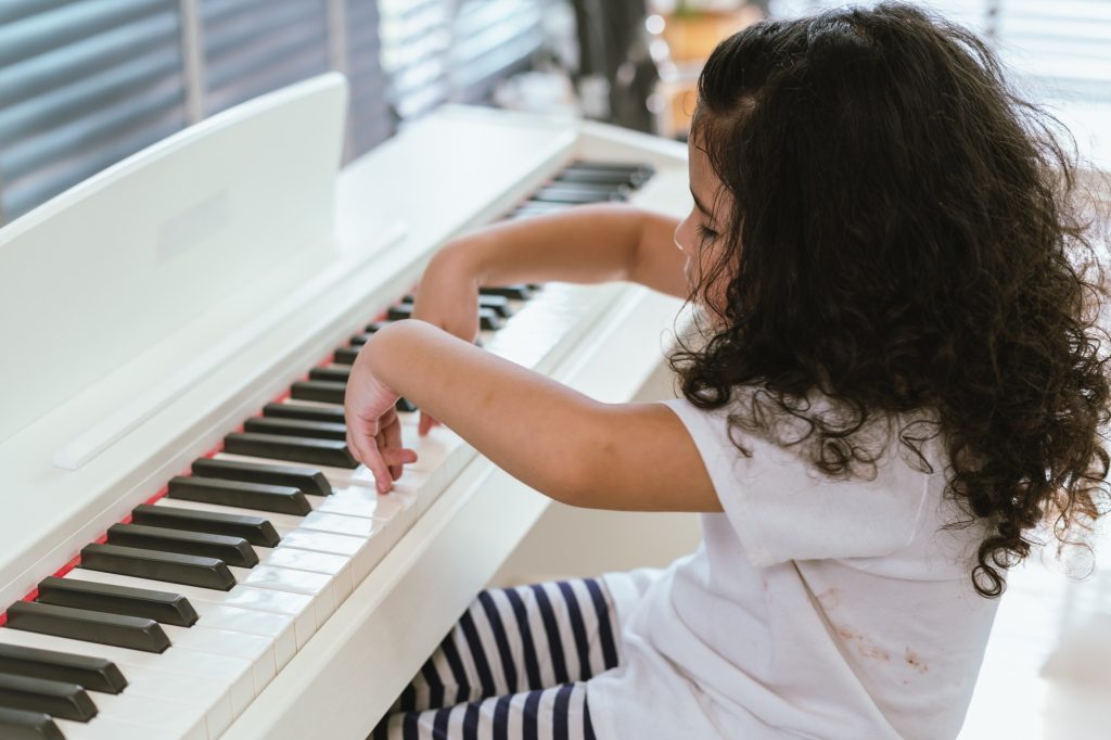 Melodies of Joy, Happy Child Playfully Embracing the Piano