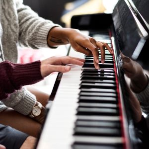 Couple praticing on a piano together