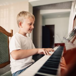 little happy boy plays piano